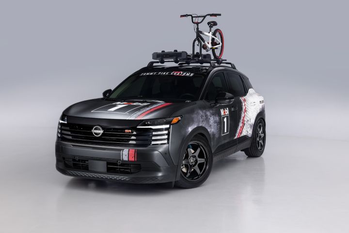 Front left 3/4 angle of the Nissan Kicks Urban Shadow with a water sport bike attached to the utility rack.