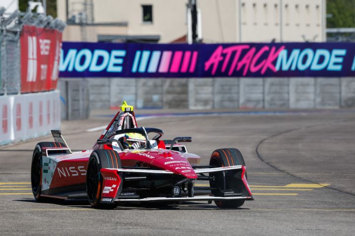 Nissan Formula E Fahrer Oliver Rowland auf der Strecke beim Berlin E-Prix mit den Attack-Mode-Zeichen im Hintergrund