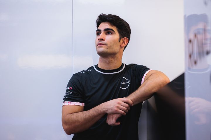 Landscape image of Nissan Formula E Team Reserve and Simulator Driver Sérgio Sette Câmara wearing his team polo shirt in the garage.