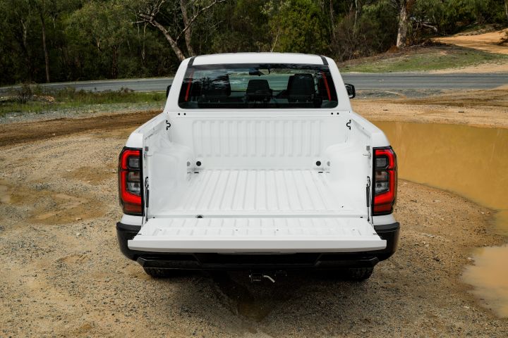 2026 Nissan Navara SL dual cab ute finished in Alpine White shown from the rear with the tailgate down, exposing the empty tub and ribbed load bed.