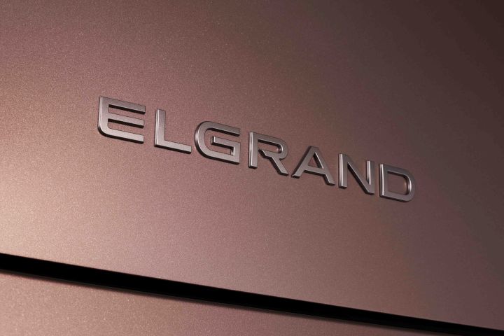 Another close-up of the “ELGRAND” badge on the body of a Fuji-dawn-colored Elgrand, emphasizing the model name emblem.