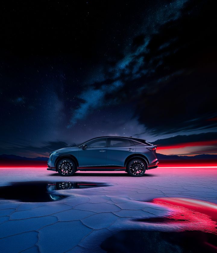 Side view static shot of the Ariya Nismo with red lighting in the background
