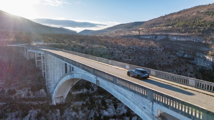 Photo de l’Ariya NISMO roulant seul sur un viaduc.