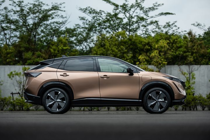 Nissan Ariya stojący bokiem na tle drzew