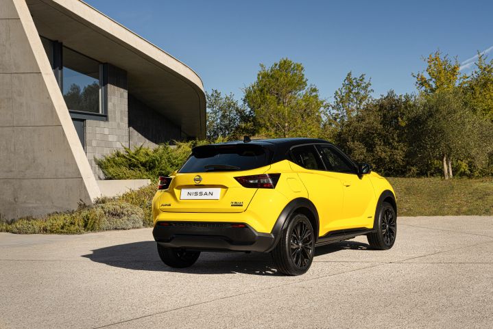 Gelber Nissan Juke 3/4 Heck auf hellem Untergrund im Hintergrund helles Gebäude und Grünfläche