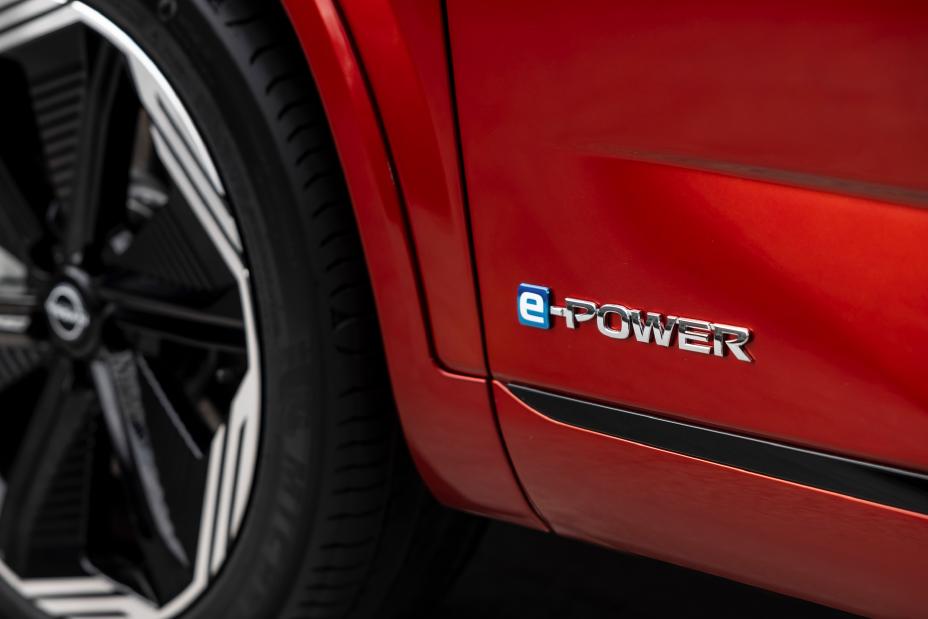 Gros plan du logo e‑POWER apposé sur le bas de porte du nouveau Nissan Qashqai rouge.