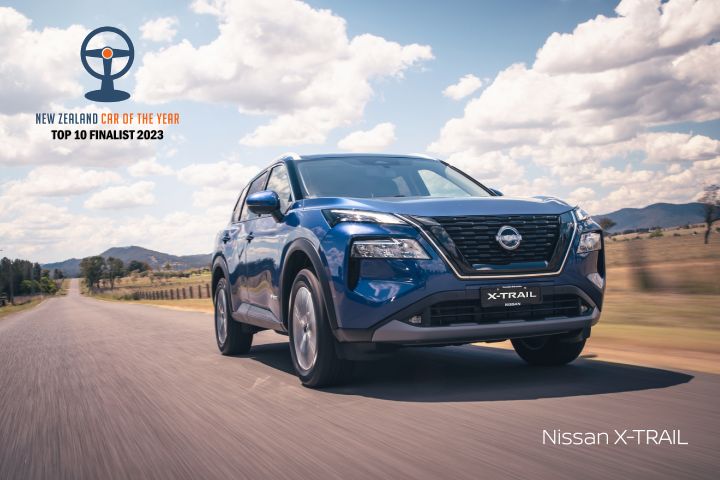 Nissan X‑TRAIL driving on a road heading right