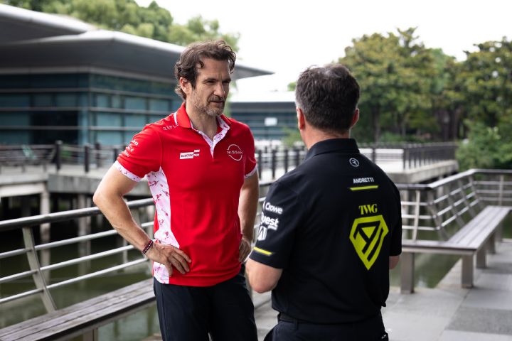 Bild im Querformat von Tommaso Volpe, Geschäftsführer und Teamchef des Nissan Formula E Teams, und Roger Griffiths, Teamchef von Andretti Formula E, im Gespräch, wobei Volpe die Arme verschränkt hat und Griffiths mit dem Rücken zur Kamera steht.
