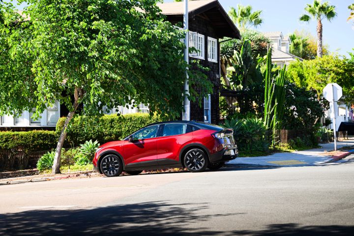 2026 Nissan LEAF parked in front of a house with tropical trees and landscaping nearby.