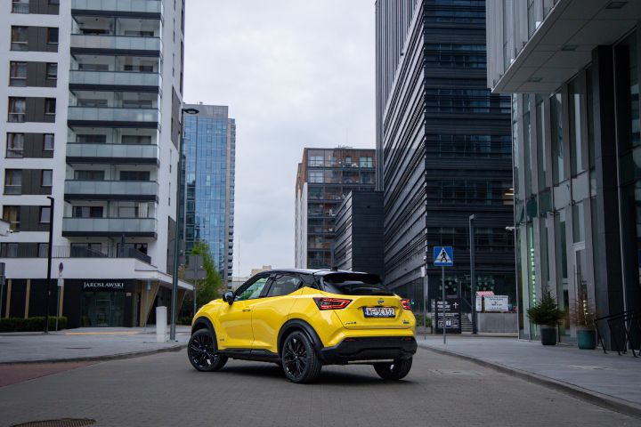 Żółty Nissan Juke stojący tyłem z budynkami w tle