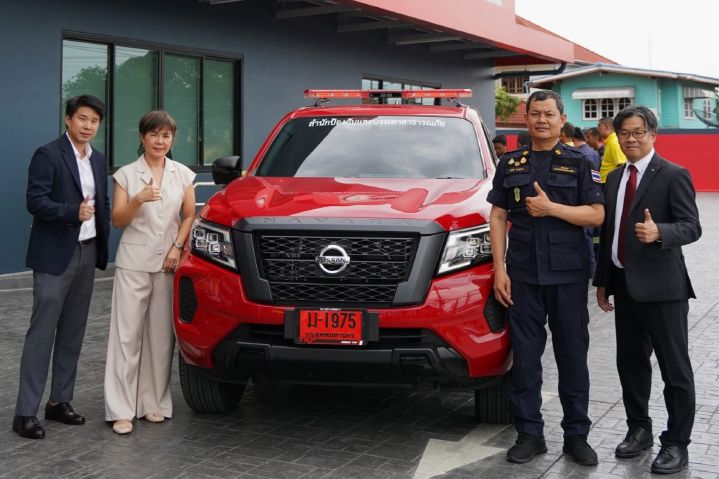 Group photo of Nissan representatives deliver a red Nissan Navara to the representative of Fire and Rescue Department