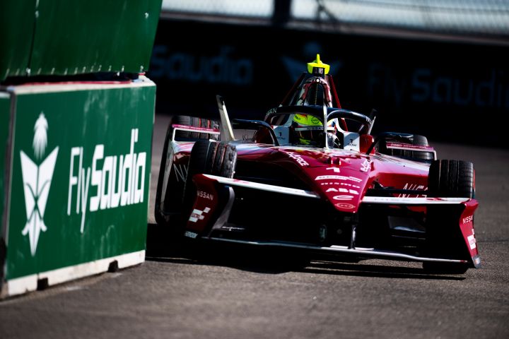 Oliver Rowland am Steuer des Nissan e‑4ORCE 05 mit der Startnummer 1 in Berlin, mit grünen Werbetafeln auf der linken Seite des Fotos.