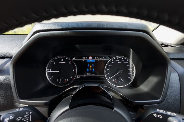 2026 Nissan Navara SL dual cab ute finished in Alpine White shown with a tight dashboard view of the instrument binnacle, analogue gauges and centre display presenting the drivetrain information screen.
