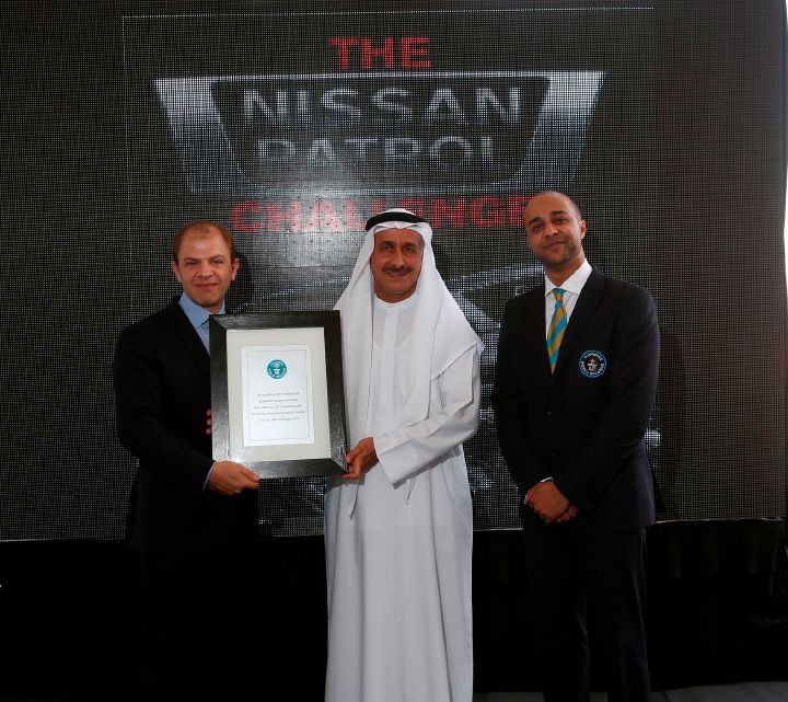 three men being photographed with a Guinness World Record