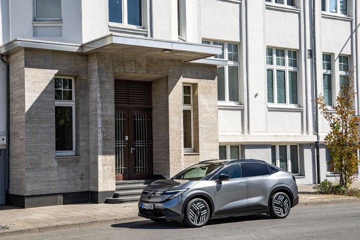 Seiten- und Frontansicht eines grauen Nissan Lead vor einem weißen Haus mit historischer Fassade