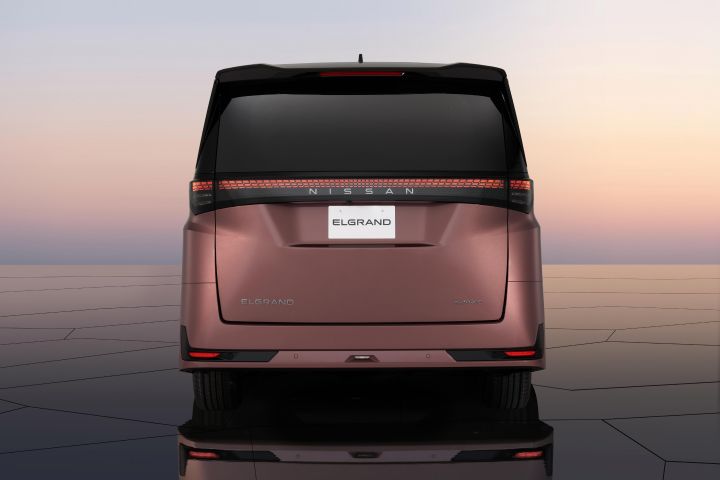 A close-up of the “e‑4ORCE” badge on the body of a Fuji-dawn-colored Elgrand, clearly showing the emblem that represents advanced all-wheel control technology.