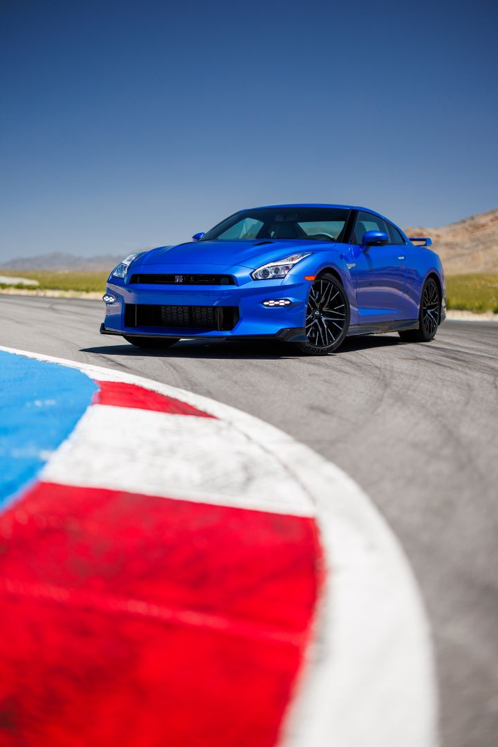 Front 3/4 image of a 2024 GT‑R Special Edition with the corner of a turn in a race track in the foreground and blue sky in the background