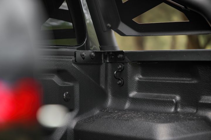 2026 Nissan Navara PRO-4X finished in Boulder Grey featuring the tub interior, sports bar mounting point and textured liner beside the rear window.
