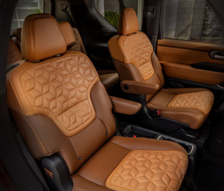 The two tone tan rear passenger seats viewed from the rear passenger door of the 2025 Nissan Armada.