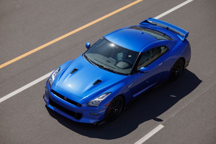 Ariel view of a blue 2024 GT‑R Special Edition driving on a public road with sun reflecting on the hood