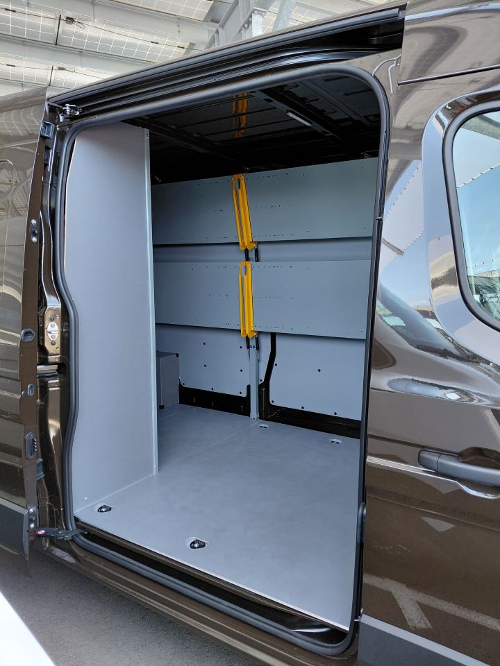 Blick durch die geöffnete seitliche Schiebetür auf die hochgeklappten Regalböden im Inneren des Nissan Interstar-e mit KEP-Umbau