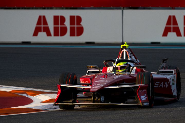 Frontalaufnahme von Oliver Rowland, der mit dem Nissan e‑4ORCE 05 mit der Startnummer 1 nach rechts in eine Kurve einbiegt, hinter ihm weiße ABB-Werbetafeln.