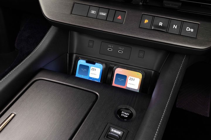 The front center console of a Fuji-dawn-colored Elgrand. Cup holders, storage space, and various control buttons are neatly arranged, reflecting high functionality.