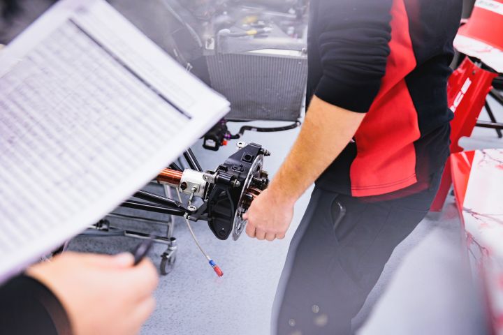 Nahaufnahme von einem Datenblatt und der Radaufhängung des Nissan Formel E Rennwagens