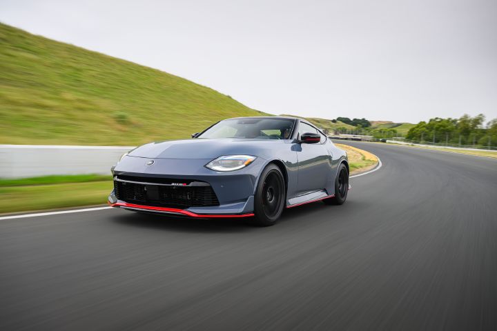 Front left 3/4 view of a 2027 Nissan Z NISMO Manual Transmission curving around a road.
