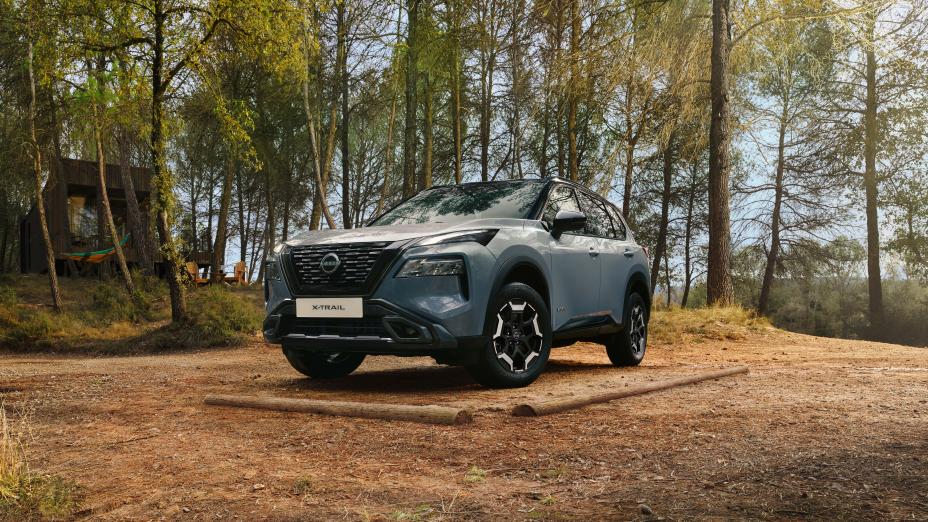 Ceremic Grey Nissan X-Trial N-Trek voorzijde 3/4 links in een bosrijke omgeving