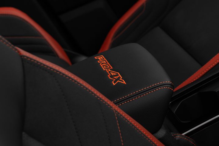 2026 Nissan Navara PRO-4X finished in Boulder Grey centring on the PRO-4X armrest, orange stitching, seat bolsters and console storage area.