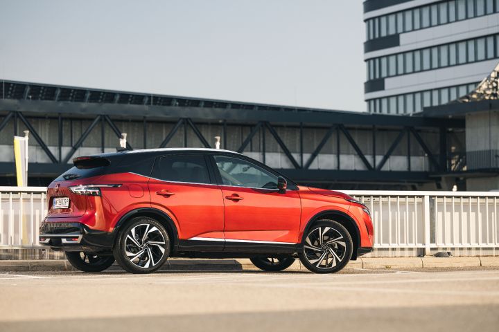 Seitenansicht eines parkenden Nissan Qashqai in Fuji Sunset Red