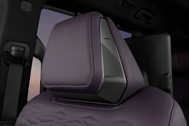 A close-up of a seat in a Fuji-dawn-colored Elgrand. The headrest and part of the backrest are shown, with leather material and fine stitching creating a luxurious feel.