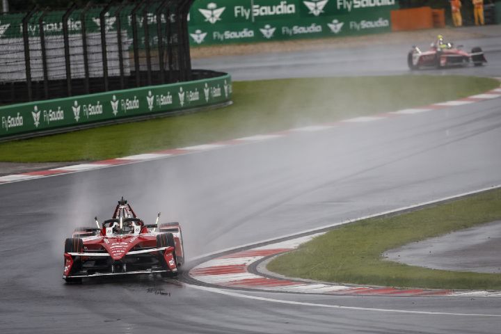 Frontalaufnahme von Norman Nato im Auto mit der Startnummer 23 auf nasser Strecke in Shanghai, wobei Wasser vom Auto aufspritzt.