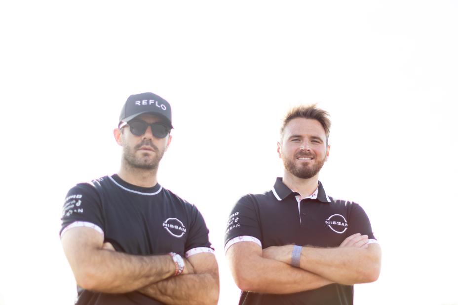 Norman Nato w czapce Reflo i koszulce zespołu Nissan Formula E Team zaprojektowanej przez Reflo, a Oliver Rowland w koszulce polo zaprojektowanej przez Reflo, obaj ze skrzyżowanymi ramionami.