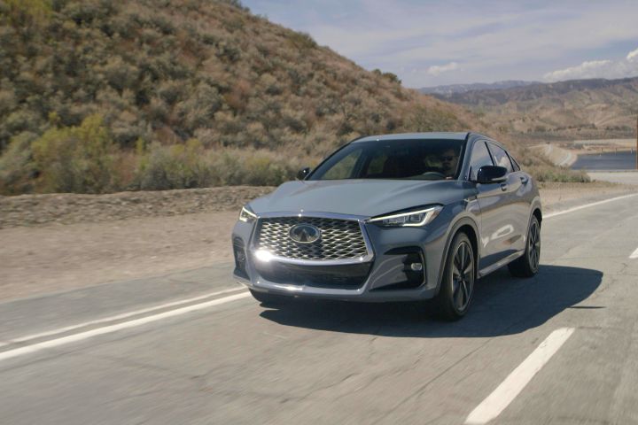 the 2022 INFINITI QX55 SENSORY Grade in Slate Gray on the road next to a hill
