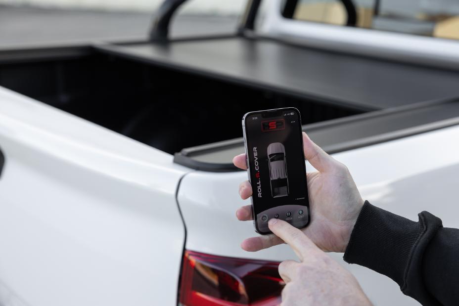 Man using his phone to close an electronic, app-operated tailgate cover