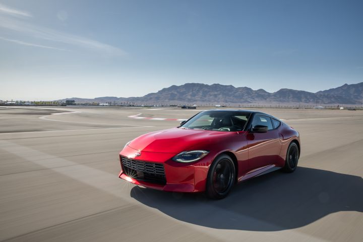 Red 2023 Nissan Z driving down the road.