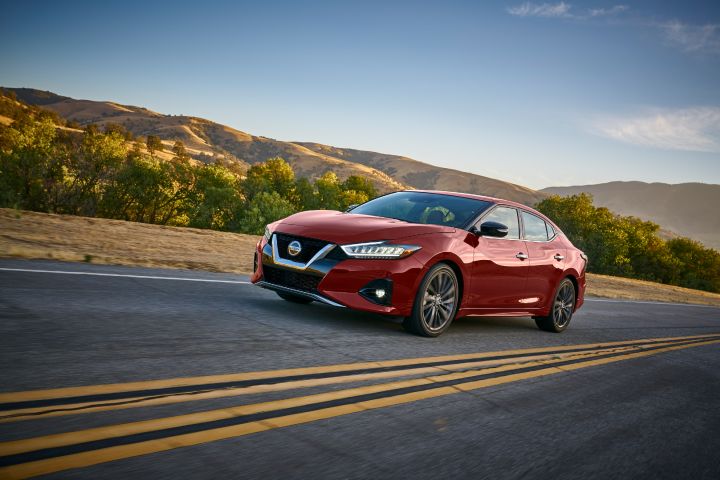 A angled photo of a red 2019 Nissan Maxima driving down a road