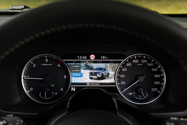 Driver’s view of the 7-inch TFT Display Instrument Cluster in a 2026 Nissan Navara ST‑X, showing the off-road drive mode menu with Snow selected and a terrain illustration on the centre screen.