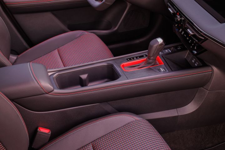 The middle console that features bright red tubing around the gear shift pocket inside the 2025 Nissan Kicks