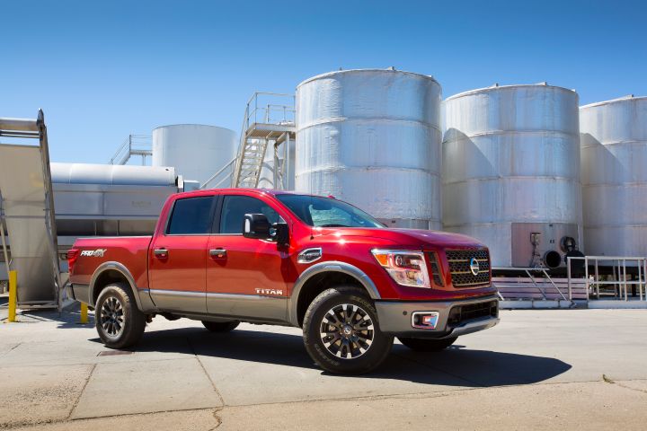A Nissan TITAN parked in front of large industrial tanks