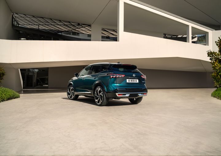 Statische 3/4 Heckansicht eines dunkelgrün-blauen Nissan Qashqai mit e‑Power-Antrieb der nächsten Generation
