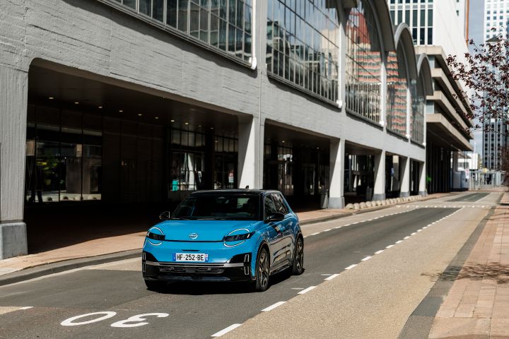 Frontale Fahraufnahme eines blauen Nissan Micra auf einer Straße im städtischen Umfeld von Rotterdam