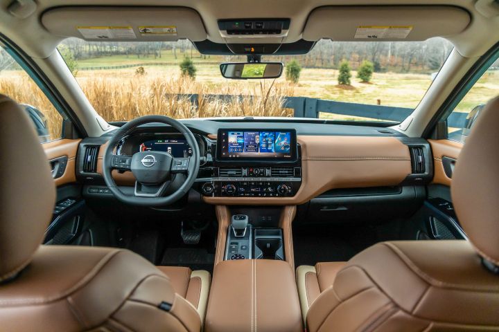 The steering, dashboard and windshield inside the 2026 Nissan Pathfinder as viewed from the back seats.