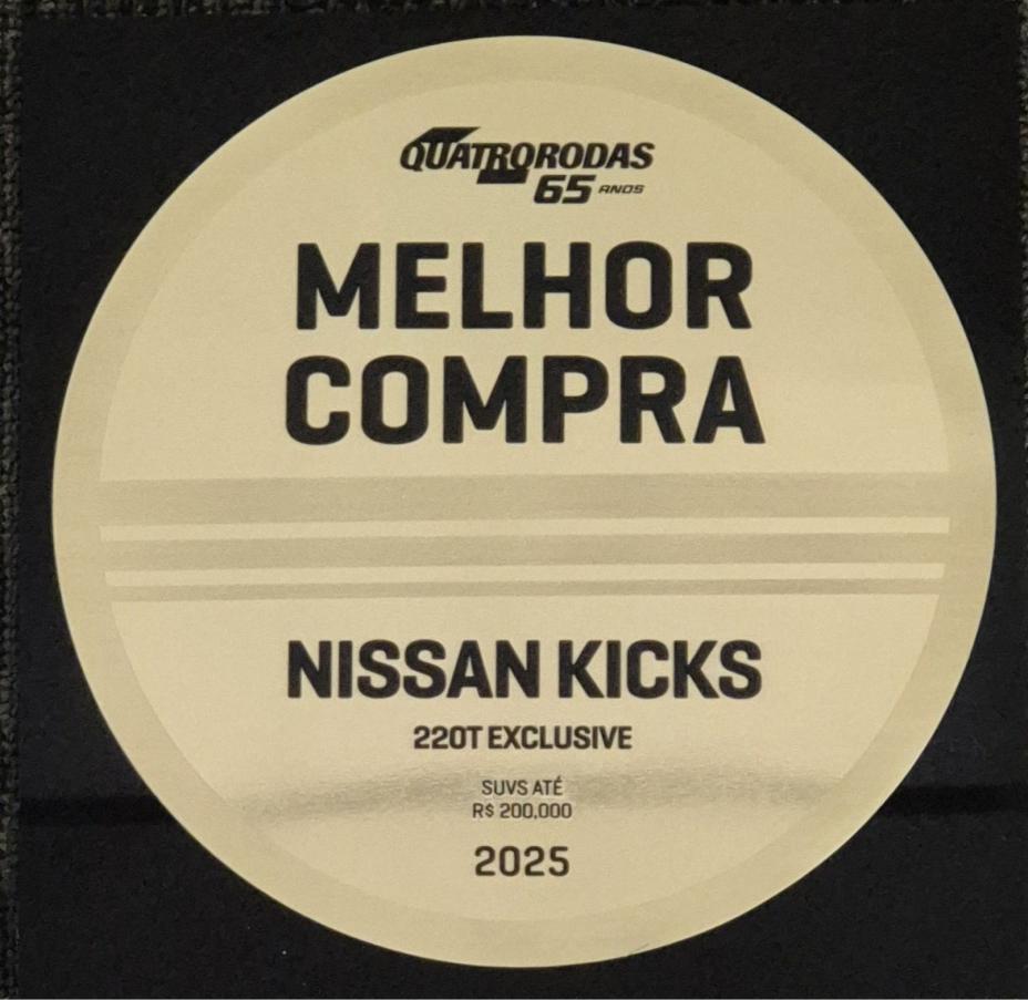 Placa redonda e dourada traz o símbolo da Quatro Rodas e o escrito Melhor Compra, Nissan Kicks 220T Exclusive, 2025