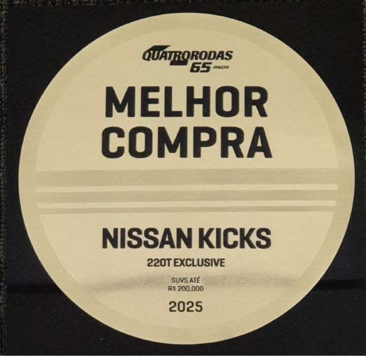Placa redonda e dourada traz o símbolo da Quatro Rodas e o escrito Melhor Compra, Nissan Kicks 220T Exclusive, 2025