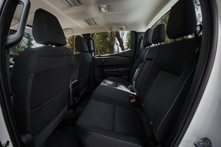2026 Nissan Navara SL dual cab ute finished in Alpine White featuring the rear cabin bench, headrests, seatbacks, rear door trim and overhead ventilation outlets.