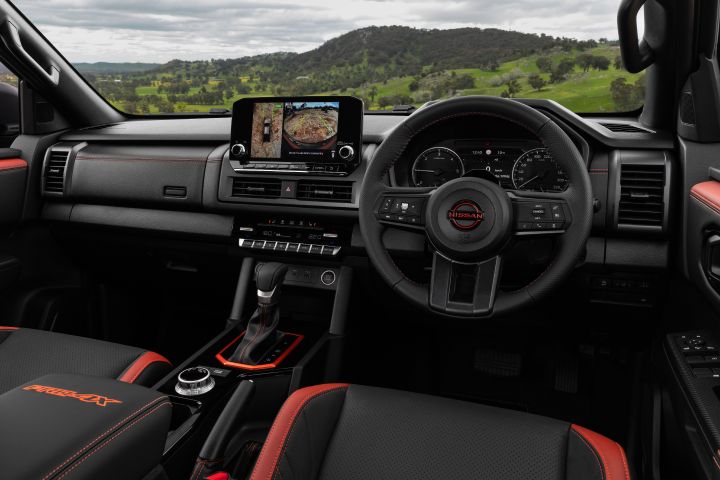 2026 Nissan Navara PRO-4X finished in Boulder Grey showing the full cabin with off-road camera display, dashboard, centre console and front seats.