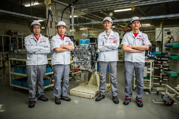 Four Nissan employees standing together with their arms crossed.